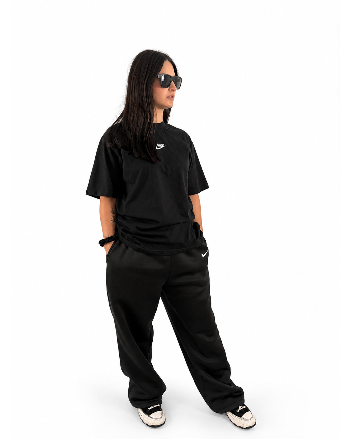 Modelo NUVA con outfit Total Black: playera y pants negros, foto de estudio.
