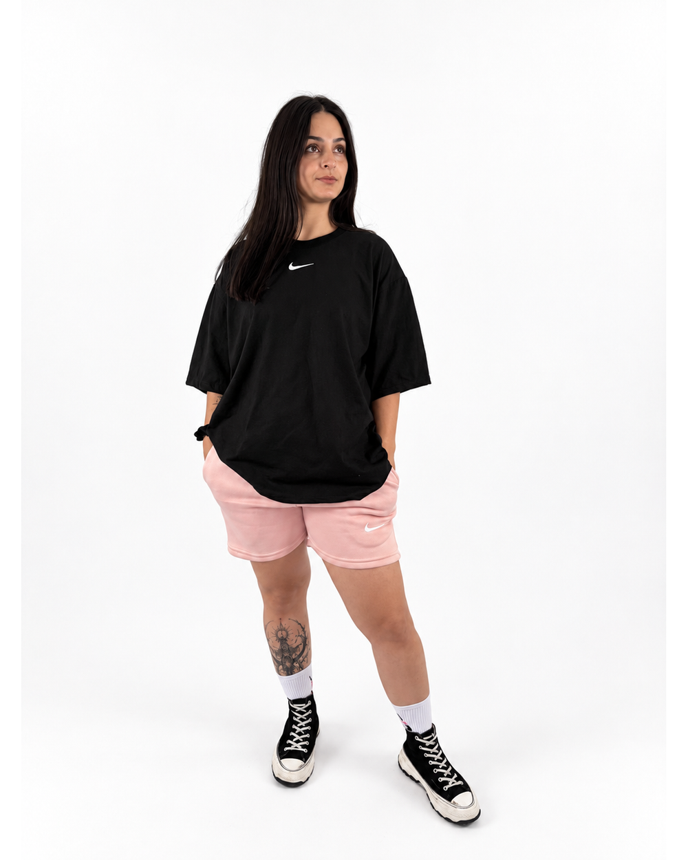 Modelo mujer con playera negra y short rosa NUVA, vista frontal.