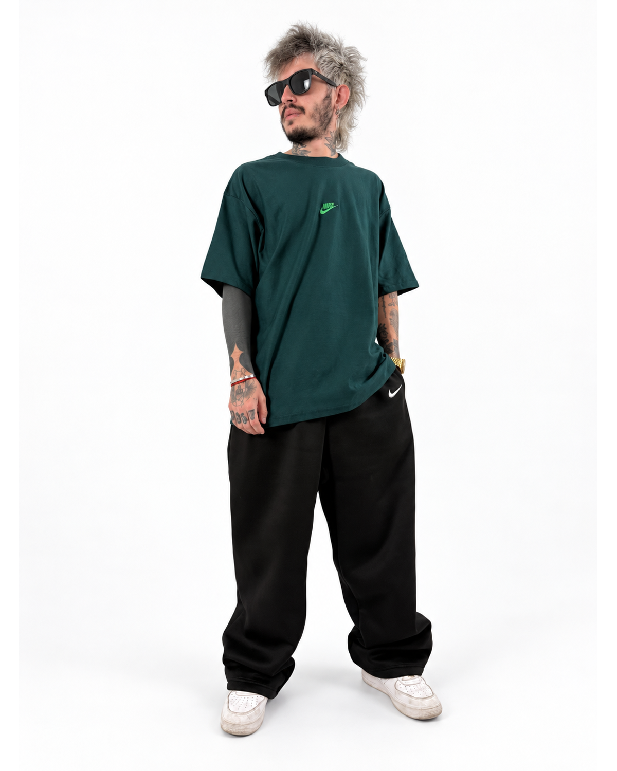 Modelo NUVA con playera oversized verde oscuro y pants negro, foto de estudio.